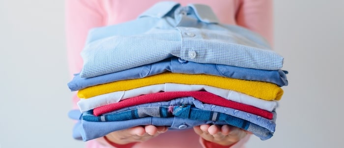 Girl Holding Pile Of Washed And Ironed Clothes